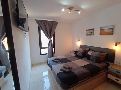 sypialnia z łóżkiem i telewizorem w obiekcie Apartamento Reload Complex Amaya Fuerteventura w mieście Costa de Antigua