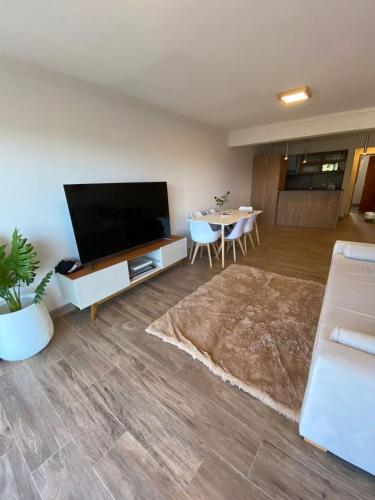 ein Wohnzimmer mit einem Flachbild-TV und einem Tisch in der Unterkunft Departamento en el Corazon de Bariloche in San Carlos de Bariloche