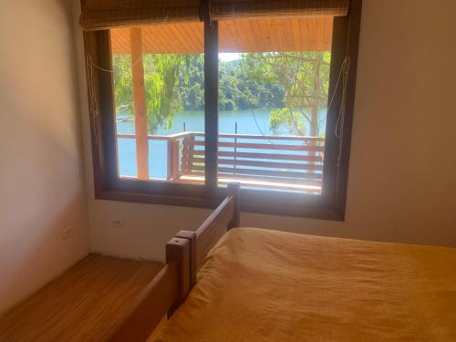a bedroom with a bed and a large window at Casa INTI Refugio Romantico Pague duas noites minimo e a terceira e brinde, menos feriados in Natividade da Serra
