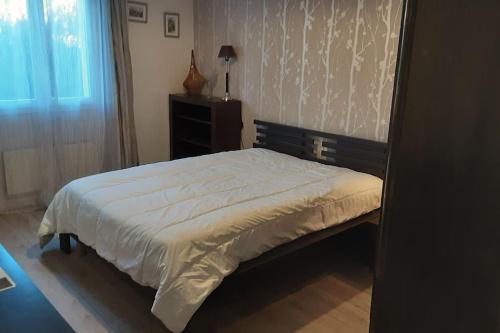 - une chambre avec un lit doté d'une tête de lit en bois dans l'établissement Grand T1 meublé, à Saint-Flour