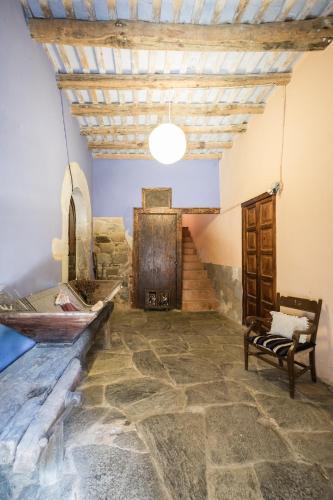 een kamer met een stenen vloer en een houten deur bij Rectoria Santuari del Coll in Girona