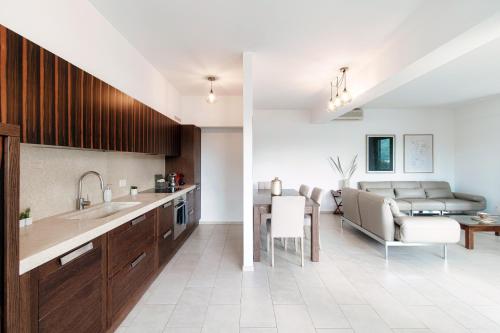 a kitchen with a sink and a dining room at The Central Home by Quokka 360 - Next to Lido di Lugano in Lugano