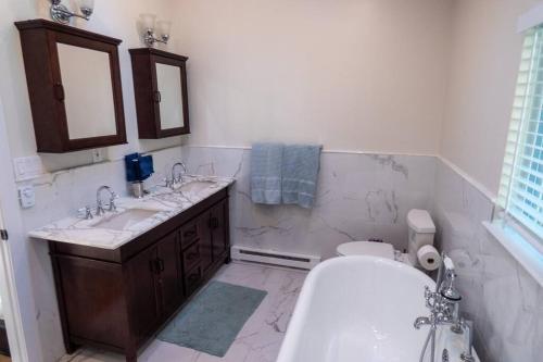 a bathroom with two sinks and a toilet and a tub at Sun Drenched Lakefront Cove in Monticello