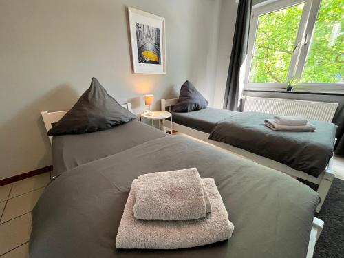 een kamer met 2 bedden en handdoeken erop bij Apartment Central 10E 90qm Wi-Fi free Parking calm back house in Dortmund