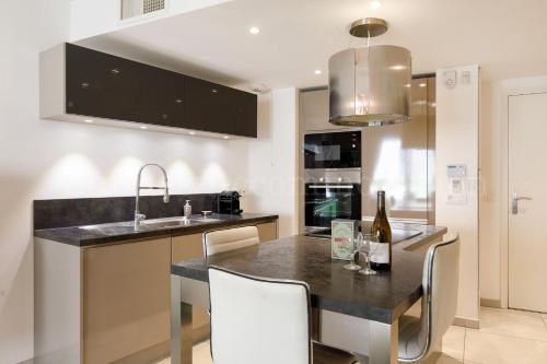 - une cuisine avec une table, des chaises et un évier dans l'établissement HSUD0116 Terracotta, à Cannes