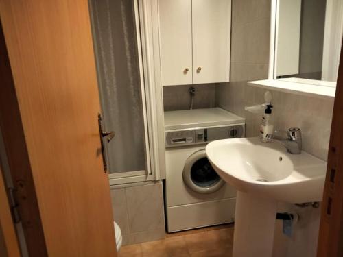 a bathroom with a washing machine and a sink at Ibón de espelunciecha in Formigal