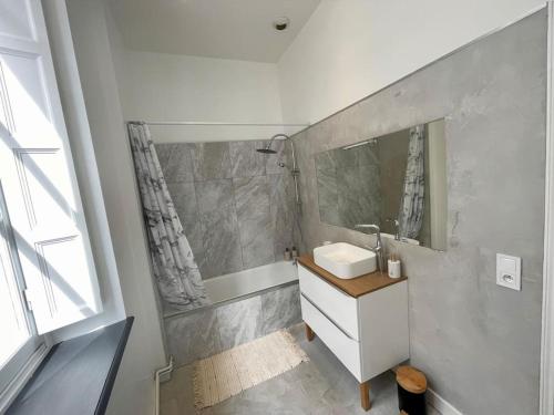 une salle de bain blanche avec un lavabo et un miroir dans l'établissement Dame Carcas, à Carcassonne