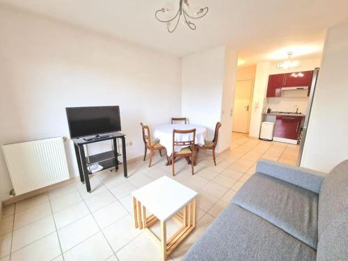 un salon avec un canapé et une table dans l'établissement Appartement T2 en centre ville, à La Teste-de-Buch