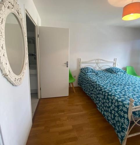 une chambre avec un lit et un miroir au mur dans l'établissement Appartement T2 en centre ville, à La Teste-de-Buch