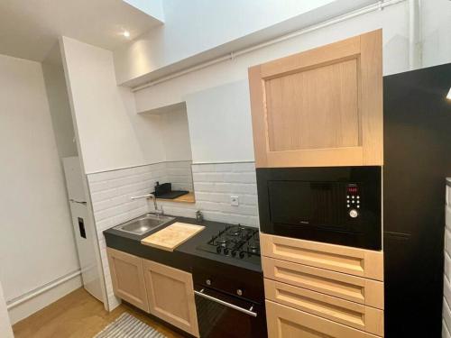 une cuisine avec une cuisinière et un micro-ondes dans l'établissement Dame Carcas, à Carcassonne