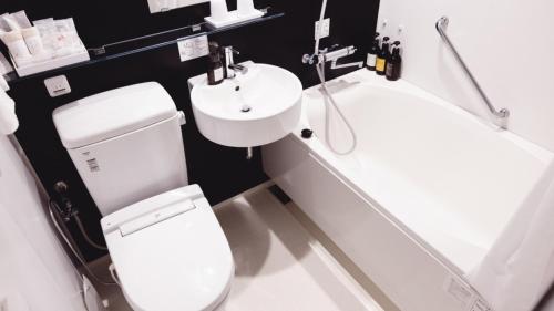 a bathroom with a toilet and a sink at AIRAIKUHOTEL kagoshima in Aira