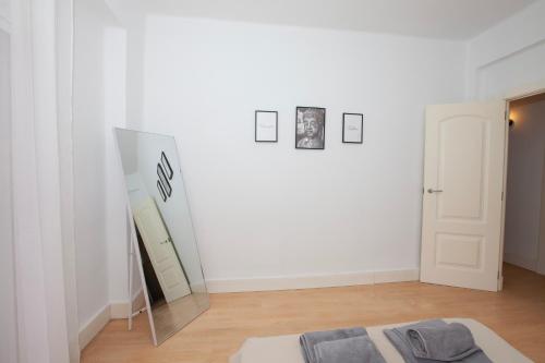 een kamer met een spiegel en een witte muur bij Precioso Apartamento en Valencia in Paterna