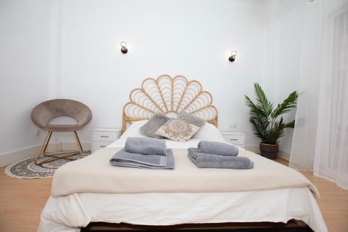 a bedroom with a bed with towels and a chair at Precioso Apartamento en Valencia in Paterna