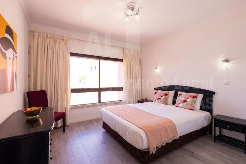 Un dormitorio con una cama grande y una ventana. en Sofia Beach Apartment by ACasaDasCasas, en Ericeira