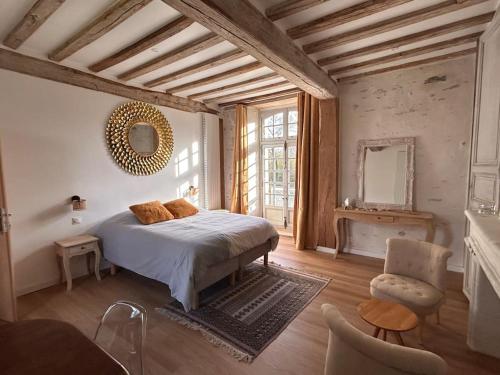 um quarto com uma cama e uma cadeira em Demeure La Lande Fleurie em Feneu