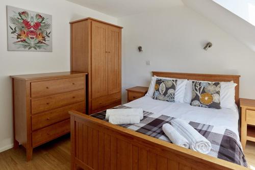 a bedroom with a wooden bed with a wooden dresser at Selwood Cottage in Beckington
