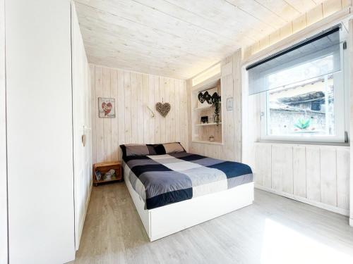a bedroom with a bed in a room with a window at You and Me nel cuore antico di Aosta in Aosta