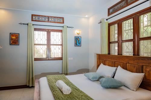 a bedroom with a large bed with two pillows at Green Square Grove - Entire House in Kampala