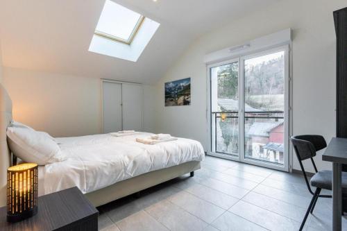 une chambre avec un lit et une grande fenêtre dans l'établissement Résidence Méri-Bellecombe, à Brides-les-Bains