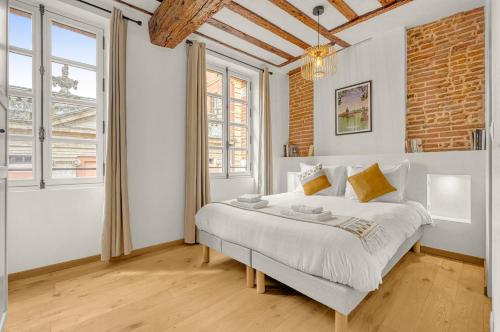 - une chambre avec un grand lit dans une pièce dotée de fenêtres dans l'établissement Monsieur Henri - Grand appt en plein centre ville, à Toulouse