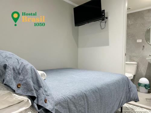 a bedroom with a bed and a flat screen tv at Hostal Brasil 1050 in La Serena