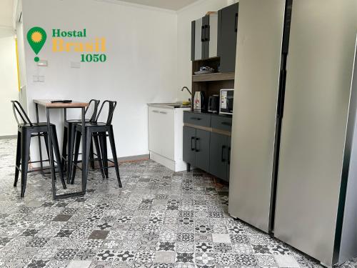 uma cozinha com uma mesa e cadeiras e um frigorífico em Hostal Brasil 1050 em La Serena