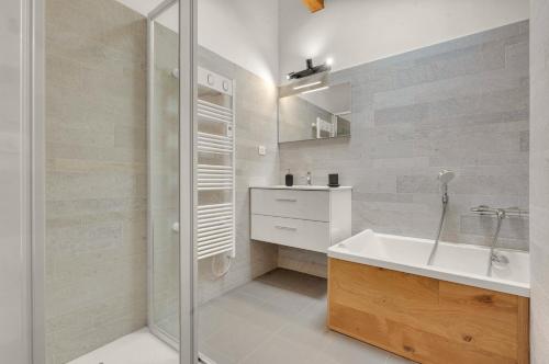 une salle de bain blanche avec un lavabo et une douche dans l'établissement Monsieur Henri - Grand appt en plein centre ville, à Toulouse