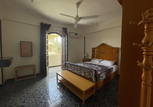 1 dormitorio con 1 cama y puerta abierta en Gîte Hôtel Gezira Louxor, en Luxor