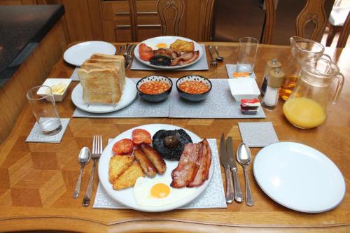 a table with plates of breakfast food on it at Westleigh House in Fishbourne