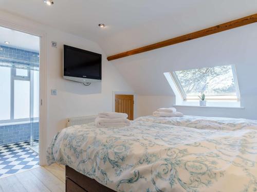 a bedroom with a bed and a tv on the wall at 2 bed in Week St Mary 82455 in Week Saint Mary