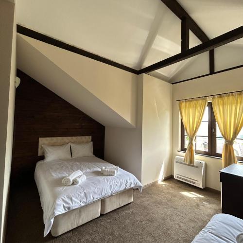 1 dormitorio con 1 cama grande con sábanas blancas en Геша Хил Парк СН21 en Balaleya