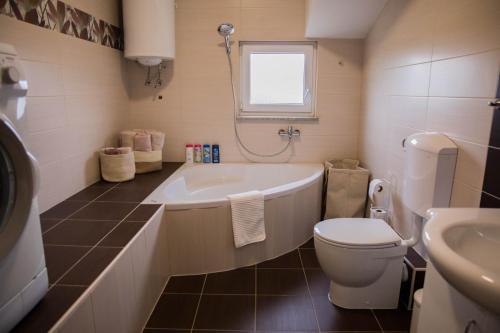 een badkamer met een bad, een toilet en een wastafel bij Villa Ero in Ljubuški