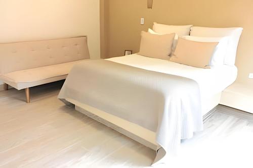 a bedroom with a large white bed and a bench at Mágica CASA FINCA de lujo piscina privada wi-fi tv in Mariquita
