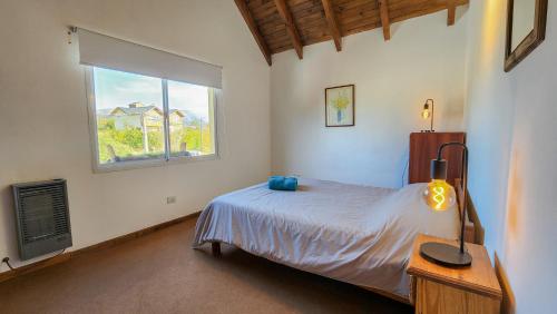 1 dormitorio con cama y ventana en La gringa 3 en San Carlos de Bariloche