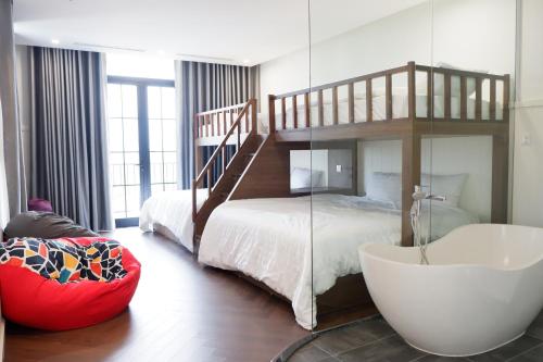 ein Schlafzimmer mit einem Etagenbett und einer Badewanne in der Unterkunft Valentina Castle - Melorita Hòa Lạc in Hanoi