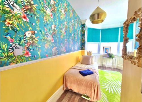ボーンマスにあるYellow Lemur Apartment - Lemur Lodge - Short Stroll to the Beach - Free Wifiのカラフルな壁画の黄色い壁のベッドルーム1室