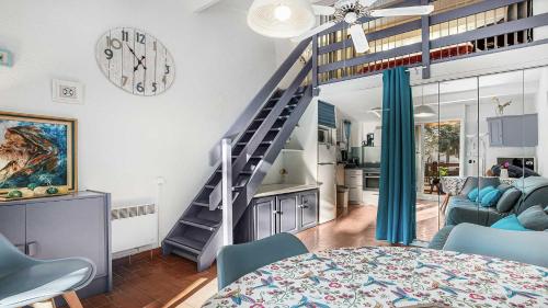 - un salon avec un escalier en colimaçon dans une maison dans l'établissement GREEN VILLAGE -7- Appt Lumineux 4 pers, au Cap d'Agde