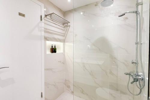 uma casa de banho com um chuveiro e uma porta de vidro em Spacious Studio In Jlt I Private Swimming Pool em Dubai