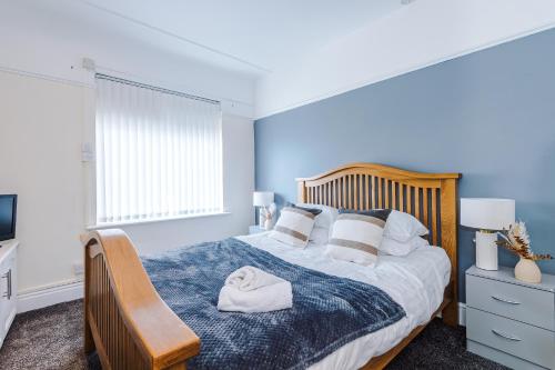 a bedroom with a bed with a wooden head board at Cosy Modern 3-BR Apartment - Sleeps 5 in Liverpool