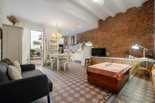 a living room and kitchen with a brick wall at Hauzify I Casa d'Anselm Clavé in Calella