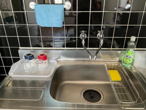 a kitchen sink with glasses and a tray in it at Warm House3 in Sapporo