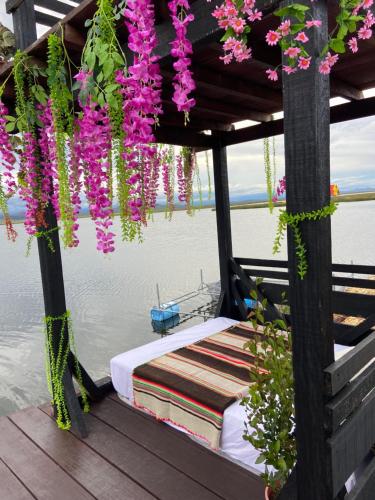 ein Bett auf einem Boot mit Blumen davon in der Unterkunft Urus Beluxia in Puno