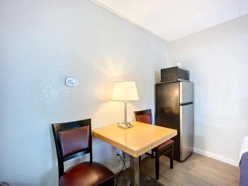 a kitchen with a table with chairs and a refrigerator at SoHo Inn and Suites Jacksonville North in Jacksonville