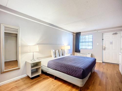 a hotel room with a bed and a window at SoHo Inn and Suites Jacksonville North in Jacksonville