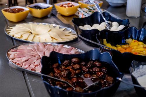 une table recouverte de différents types de denrées alimentaires dans des parties dans l'établissement Rosalita Hostel, à Lourdes