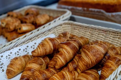 une pile de croissants et autres viennoiseries dans des paniers dans l'établissement Rosalita Hostel, à Lourdes