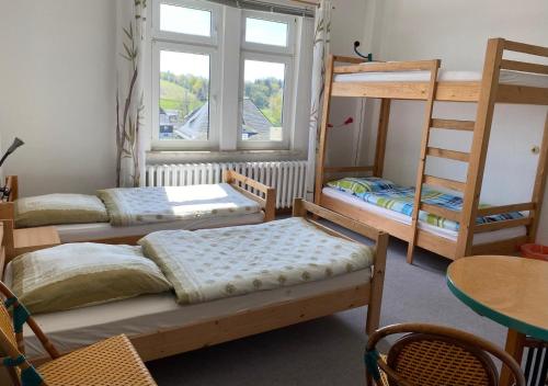 a room with three bunk beds and a window at Monteurzimmer Alte Schule Heberndorf 1 in Wurzbach