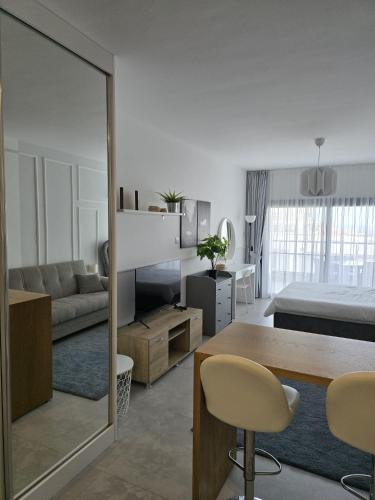 a living room with a table and a bedroom at Caesar Blue Resort Studio with Sea View in Trikomo