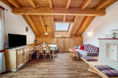 a living room with a couch and a tv at Stoffnerhof Apt Edelweiß in Tesido