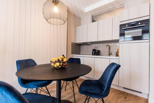 una cocina con mesa con sillas y un bol de fruta. en Apartment Viognier, en La Haya